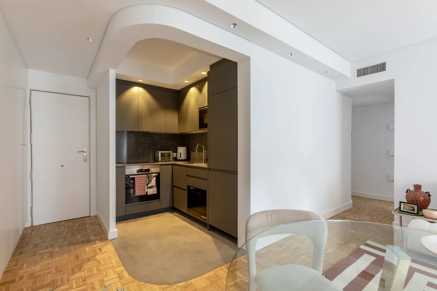 Arco entre el comedor y la cocina de la vivienda reformada en Sarrià–Sant Gervasi